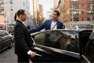 Professional chauffeur assisting a client into a luxury black car in Boston